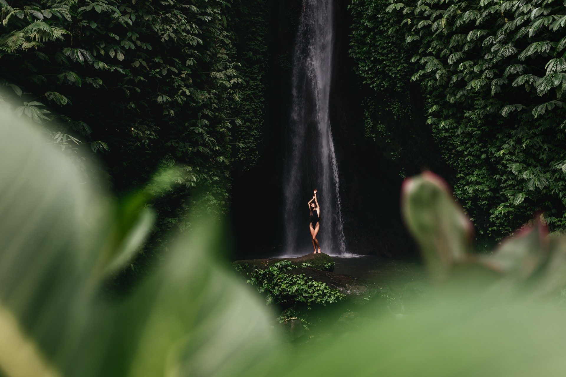 young woman backpacker looking at the waterfall in jungles.