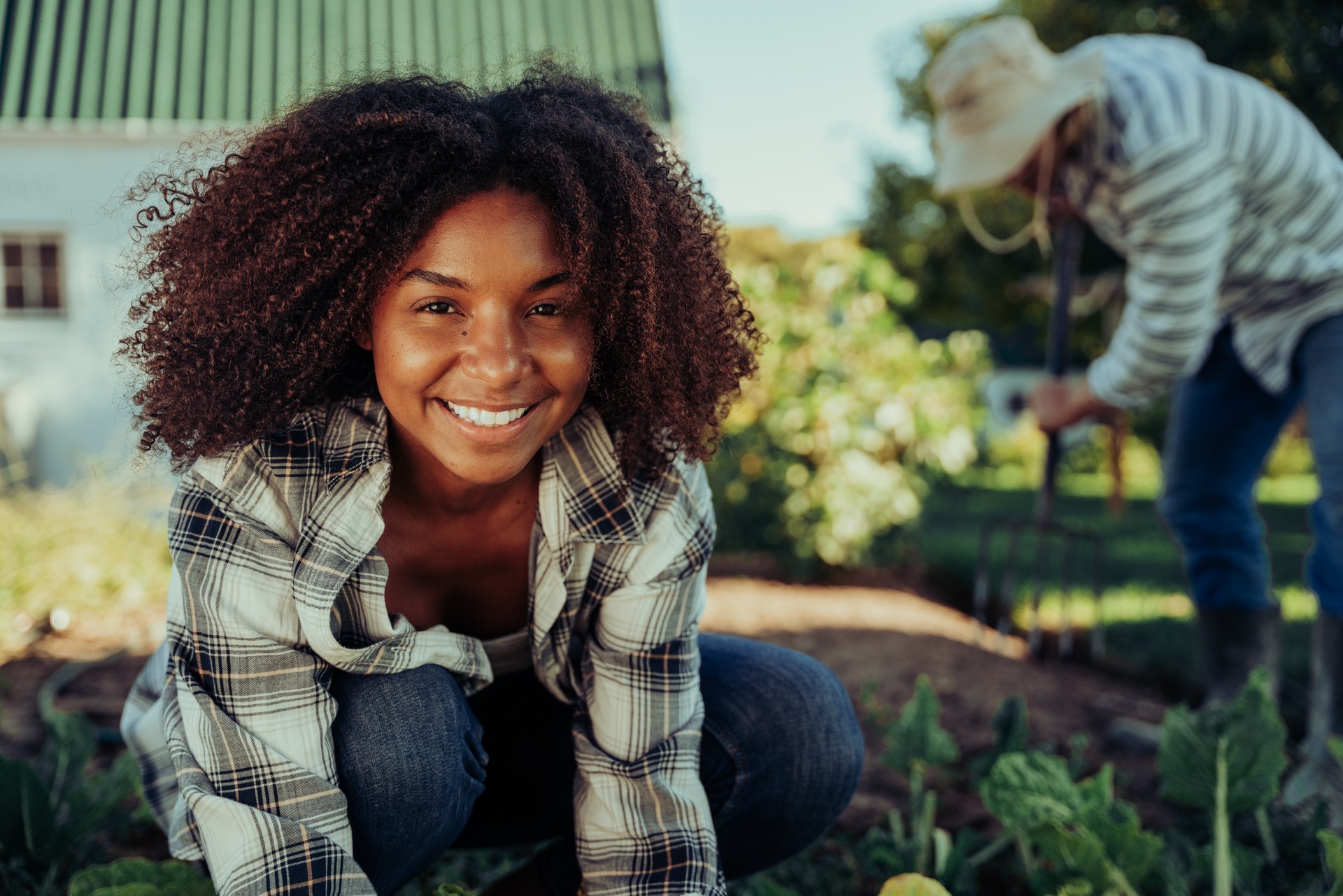 Sustainable tea practices performed by smiling female farmer working in herb garden.